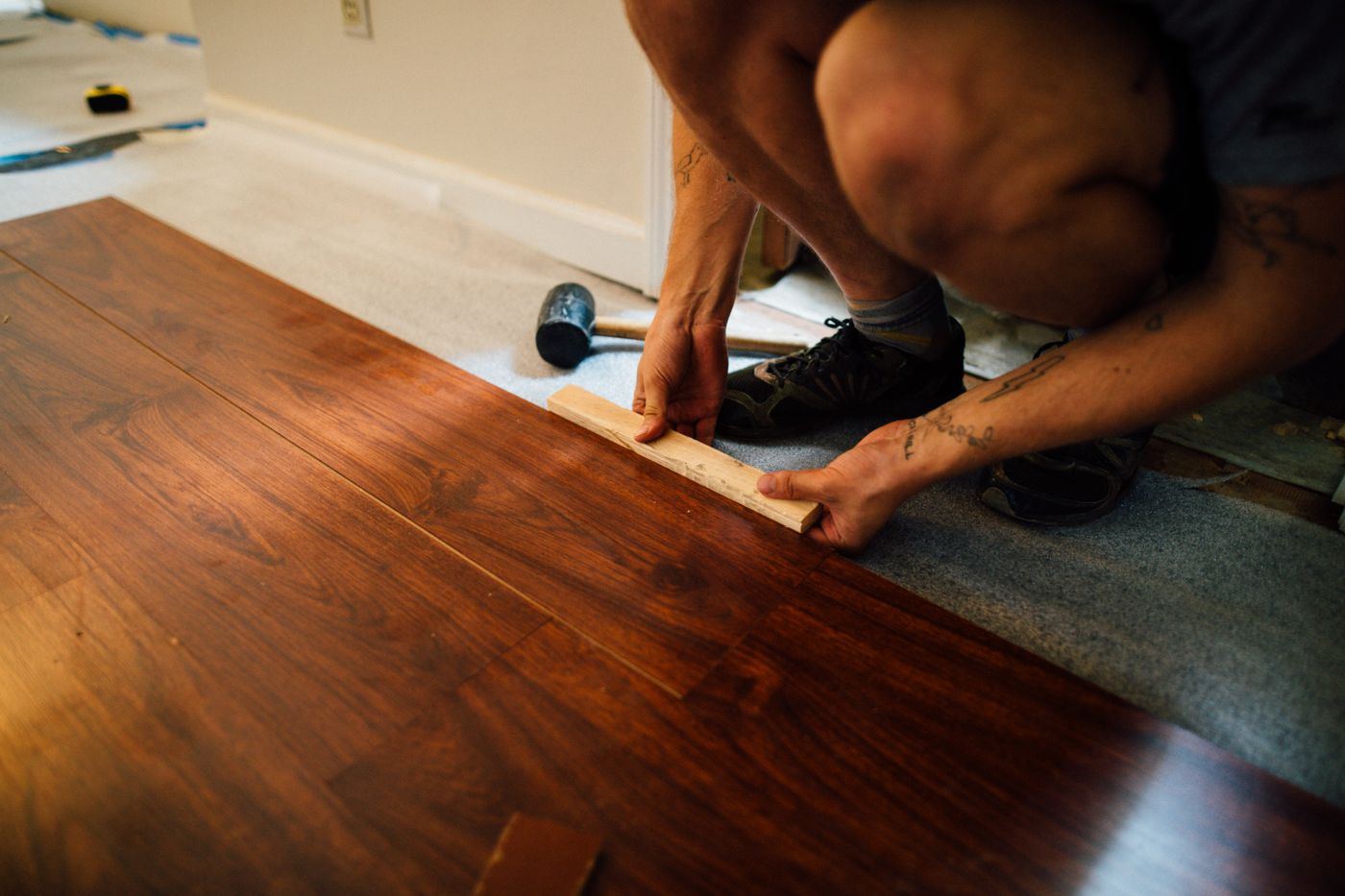 Installer setting a floor plank with a mallet