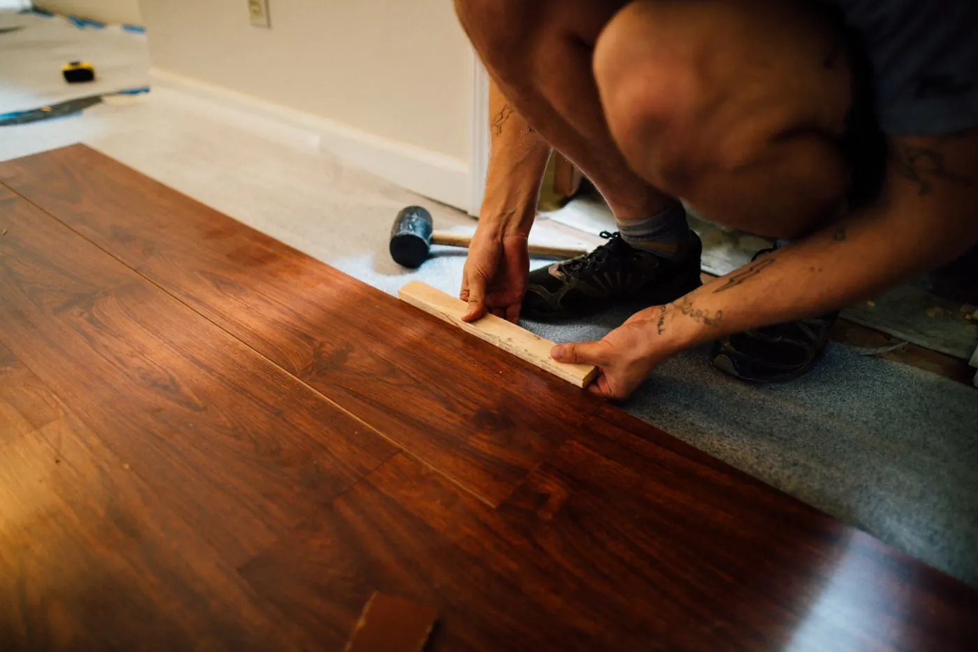 Installer setting a floor plank with a mallet