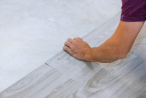 worker laying tiles and grout